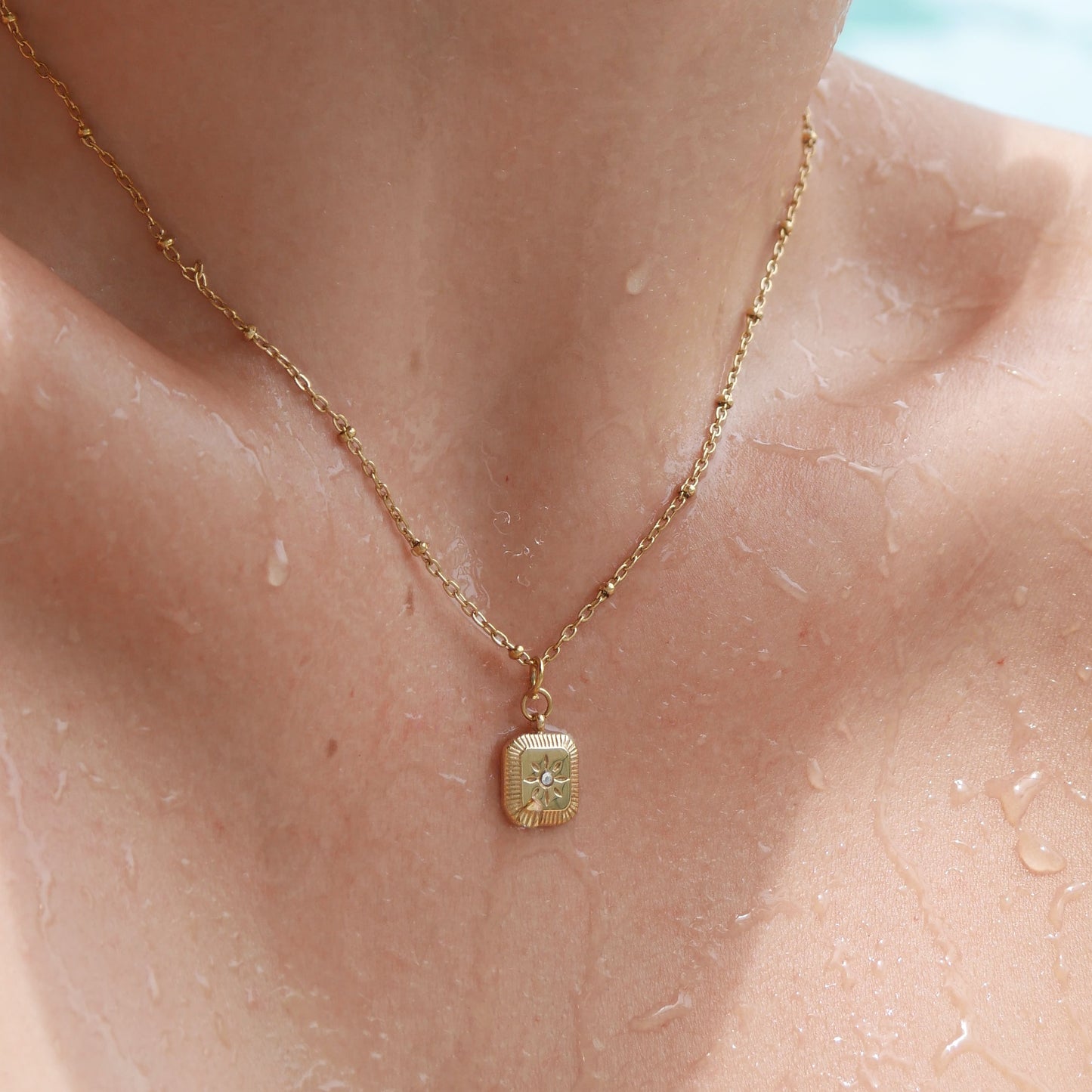 Close-up of a necklace with a pendant on a person's neck