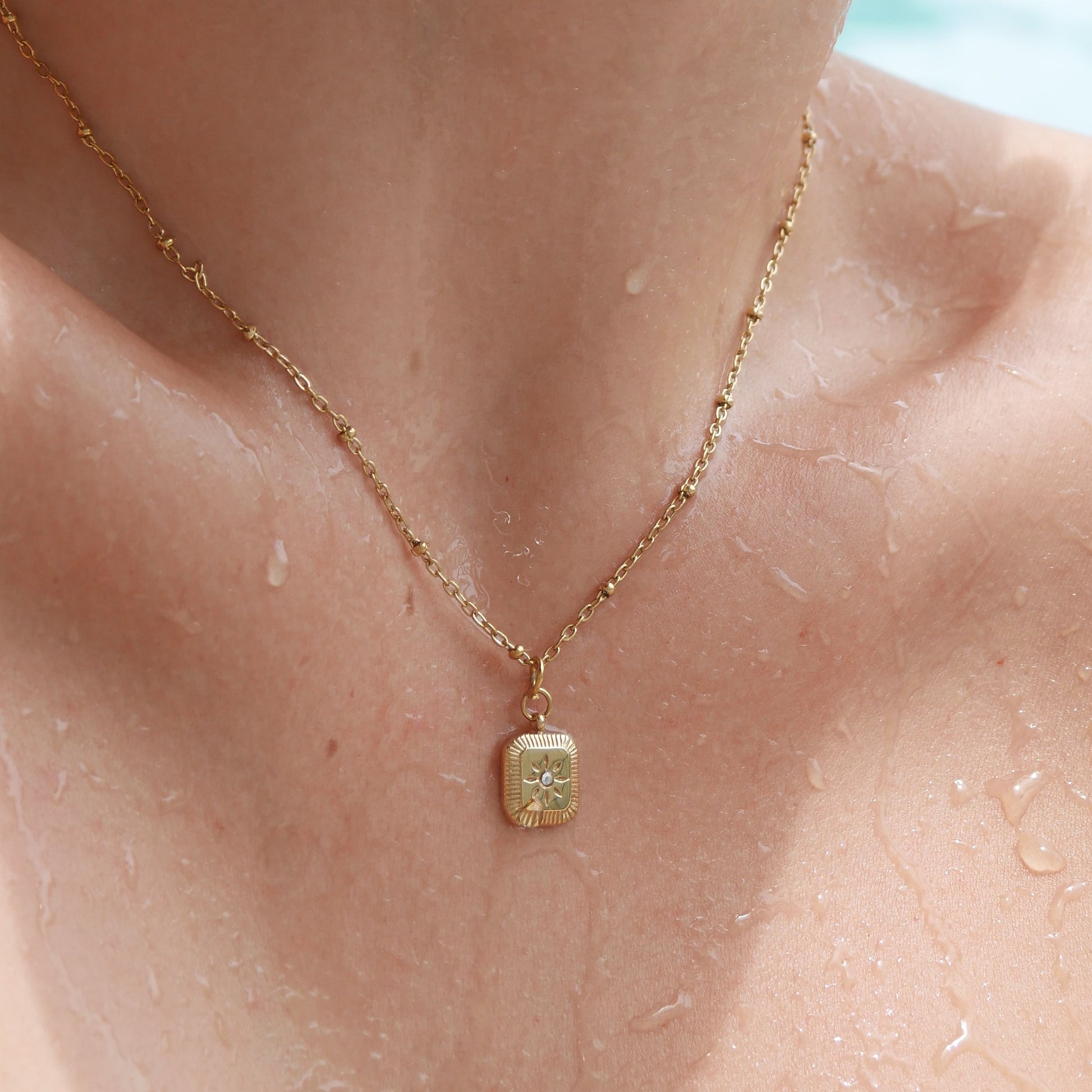 Close-up of a necklace with a pendant on a person's neck